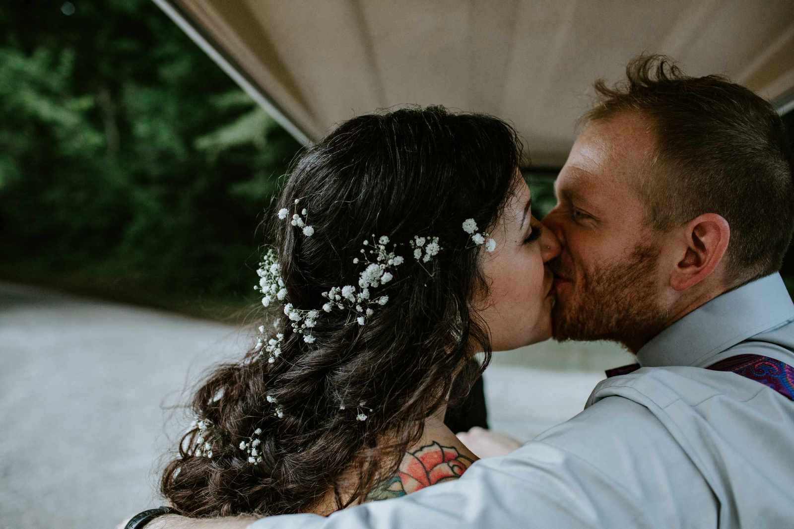 a bohemian couple kissing in the back of a golf cart